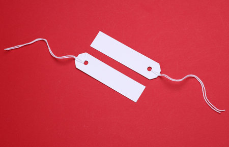 White paper tag on string on a red background