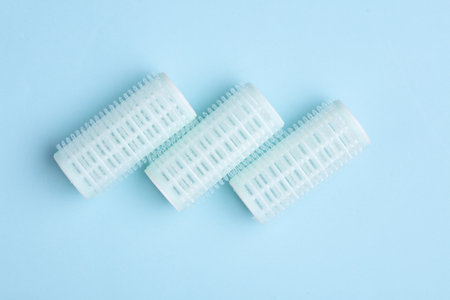 Plastic hair curlers on blue backgroundの写真素材