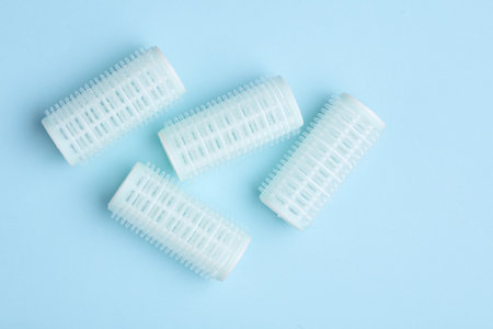Plastic hair curlers on blue backgroundの写真素材