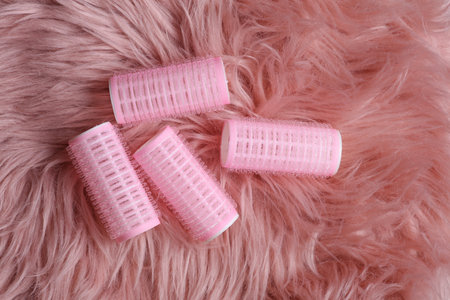 Plastic hair curlers on pink fuzzy backgroundの写真素材