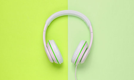Classic white wired headphones on colored paper background. Retro style. 80s. Pop culture. Top view. Minimal Music Conceptの写真素材