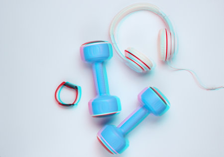 Dumbbells, smart bracelet, headphones on a white background. Minimalistic sport concept. Top view. Glitch effectの写真素材