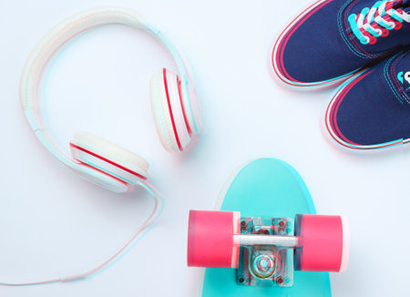 Hipster fashion look. Glitch effect. Skate, sneakers, headphones on a white background. Top view. Flat layの写真素材