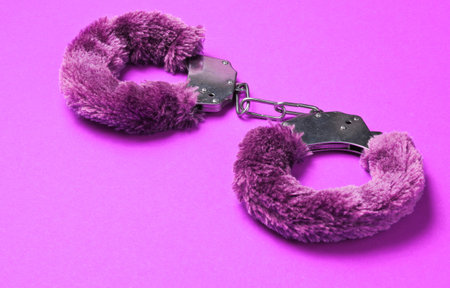 Handcuffs for sex games on pink background. Sexy bdsm toy. Fetish, erotic concept.の写真素材