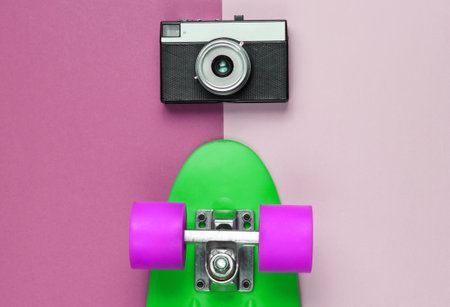 Retro set with blue skateboard and retro camera on colored background. Studio shot. Youth lifestyle. Top viewの写真素材