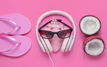 Creative summer beach background. Beach holidays. Headphones, sunglasses, coconut, shell, flip flop...