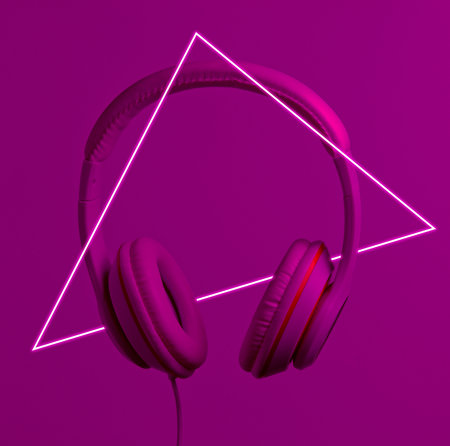 Retro wave. Headphones in neon light with a luminous led triangle. 80s