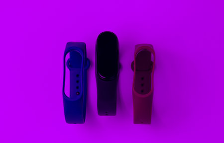 Smart watch with interchangeable bracelets in purple light. Fitness tracker. Modern gadgetsの写真素材