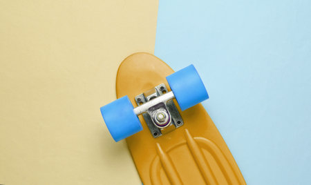 Trendy hipster skateboard on yellow blue pastel background. Minimalism concept. Youth lifestyle.の写真素材