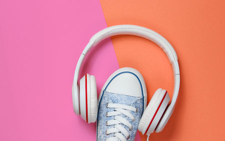 White Sneakers with headphones on colored background. Music concept. Flat lay, minimal.の写真素材
