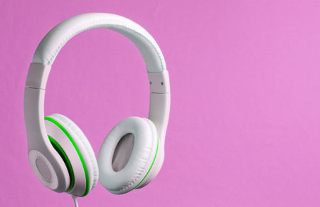 White classic wired headphones isolated on pink background. Retro style. Minimalistic music concept.の写真素材