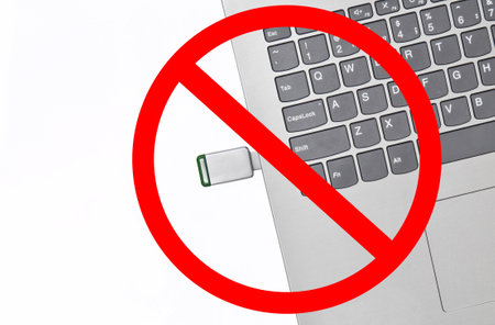 USB flash drive inserted into a laptop with prohibition sign isolated on a white background. Modern digital media.の写真素材