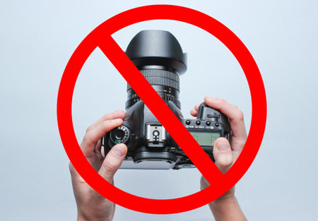 Prohibition of photography. Hands holding cameraの写真素材