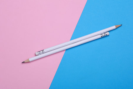 White wooden pencils with erasers on blue pink background. Mockup for designの写真素材