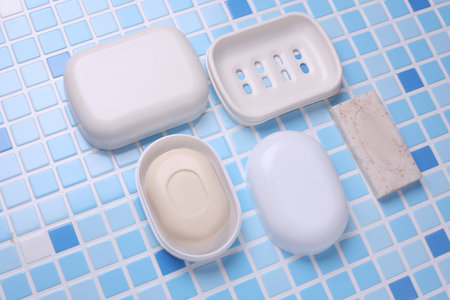 Soap dishes on tile background. Flat lay