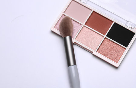 Makeup eyeshadow palette and brush on white background