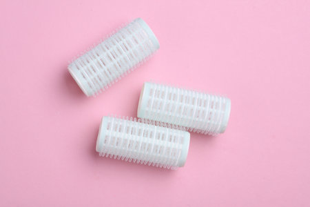 Plastic hair curlers on pink backgroundの写真素材