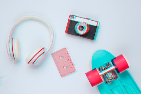 Hipster outfit. Glitch effect. Skateboard, headphones, audio cassette, retro camera on background....