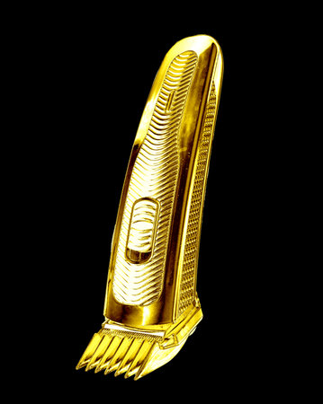 Golden Wireless clipper stands on a charging station isolated on a black backgroundの写真素材