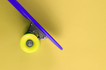 Plastic mini cruiser board on a yellow background. Summer fun. Youth minimalistic concept. Top viewの写真素材