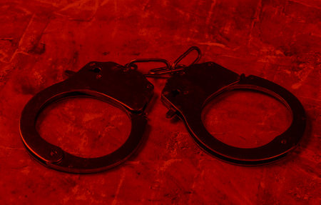 Steel handcuffs in red light. Crime, corruption conceptの写真素材