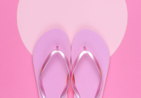 Pink flip flops on pink background with pink pastel circle for copy space. Minimalistic vacation on the beach concept. Summer time. Top viewの写真素材