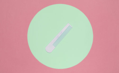 White Hair combon on blue pastel background with green pastel circle. Creative minimalistic beauty and fashion still life. Top viewの写真素材