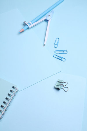 Blue Stationery set on light blue background. Back to school, education, office supplies. Monochrome...