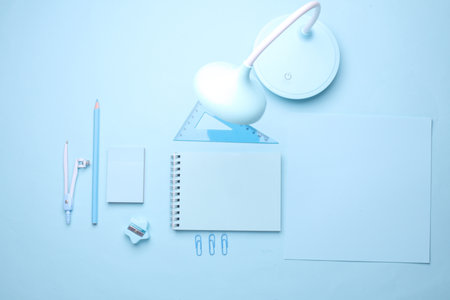 Blue Stationery set on light blue background. Back to school, education, office supplies. Monochrome photo. Flat lay. Top view. Creative layoutの写真素材