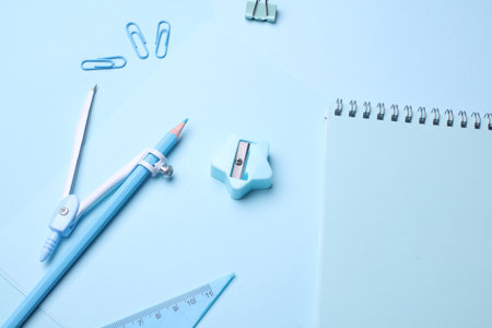 Blue Stationery set on light blue background. Back to school, education, office supplies. Monochrome photo. Flat lay. Top view. Creative layoutの写真素材