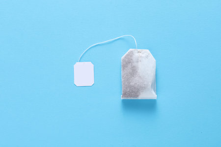Tea bag with white label on string, blue background. Mockup for design, brandingの写真素材