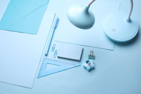 Blue Stationery set on light blue background. Back to school, education, office supplies. Monochrome photo. Flat lay. Top view. Creative layoutの写真素材