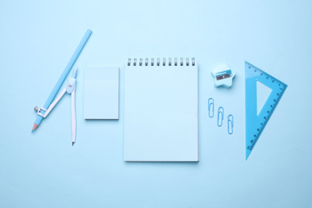 Blue Stationery set on light blue background. Back to school, education, office supplies. Monochrome photo. Flat lay. Top view. Creative layoutの写真素材