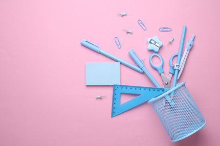 Blue Stationery set on pink pastel background. Back to school, education, office supplies. Flat lay. Top view. Creative layoutの写真素材