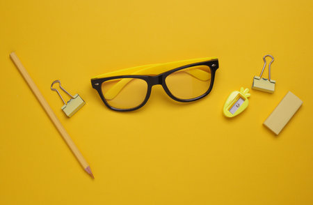 Yellow Stationery set on yellow background. Back to school, education, office supplies. Monochrome photo. Flat lay. Top view. Creative layoutの写真素材