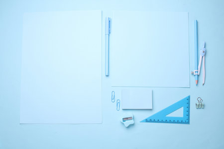 Blue Stationery set on light blue background. Back to school, education, office supplies. Monochrome photo. Flat lay. Top view. Creative layoutの写真素材