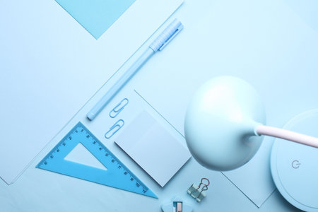 Blue Stationery set on light blue background. Back to school, education, office supplies. Monochrome photo. Flat lay. Top view. Creative layoutの写真素材