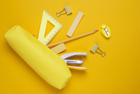 Yellow pencil case with stationery on yellow background. Flat layの写真素材