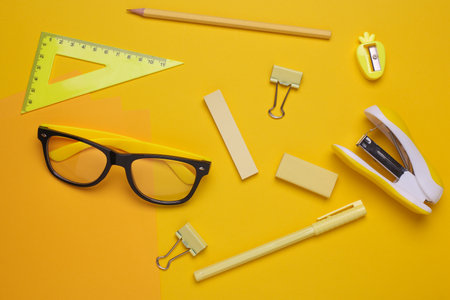 Yellow Stationery set on yellow background. Back to school, education, office supplies. Monochrome photo. Flat lay. Top view. Creative layoutの写真素材