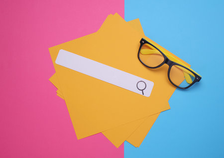 Browser search bar and yellow sheets of paper on pink blue backgroundの写真素材