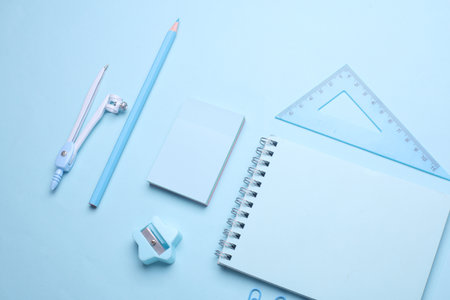 Blue Stationery set on light blue background. Back to school, education, office supplies. Monochrome photo. Flat lay. Top view. Creative layoutの写真素材