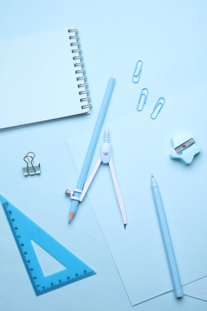 Blue Stationery set on light blue background. Back to school, education, office supplies. Monochrome photo. Flat lay. Top view. Creative layoutの写真素材