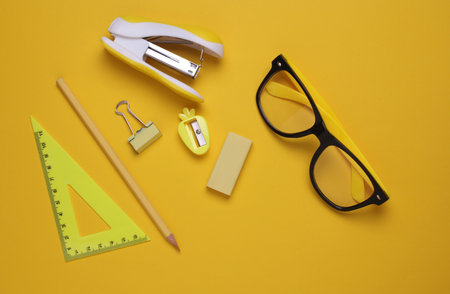 Yellow Stationery set on yellow background. Back to school, education, office supplies. Monochrome photo. Flat lay. Top view. Creative layoutの写真素材