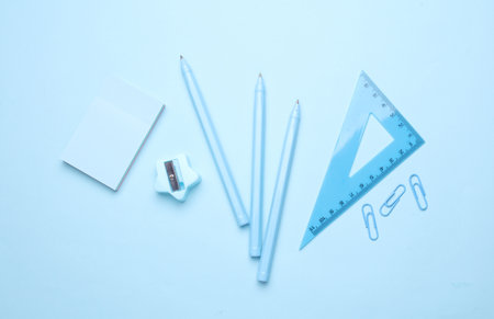 Blue Stationery set on light blue background. Back to school, education, office supplies. Monochrome photo. Flat lay. Top view. Creative layoutの写真素材