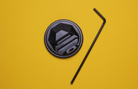 Black Drinking Straw and Lid on Yellow Backgroundの写真素材
