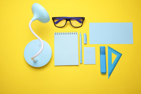 Blue Stationery set on yellow background. Back to school, education, office supplies. Flat lay. Top view. Creative layoutの写真素材