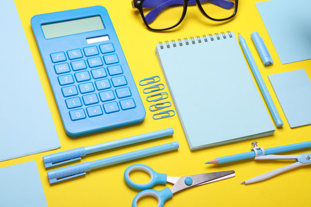 Blue Stationery set on yellow background. Back to school, education, office supplies. Flat lay. Top view. Creative layoutの写真素材