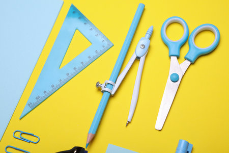 Blue Stationery set on yellow background. Back to school, education, office supplies. Flat lay. Top view. Creative layoutの写真素材