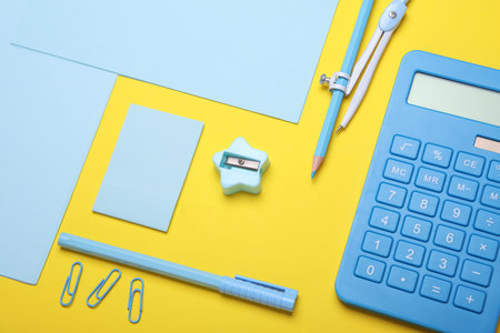 Blue Stationery set on yellow background. Back to school, education, office supplies. Flat lay. Top view. Creative layoutの写真素材