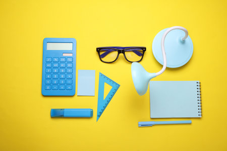 Blue Stationery set on yellow background. Back to school, education, office supplies. Flat lay. Top view. Creative layoutの写真素材